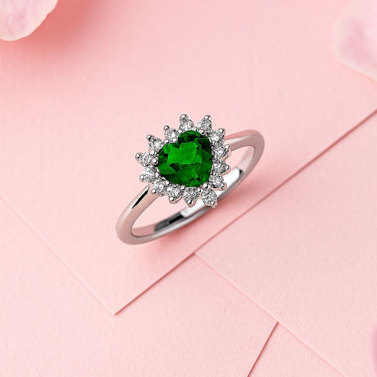 Silver ring with a green gemstone on a pink background