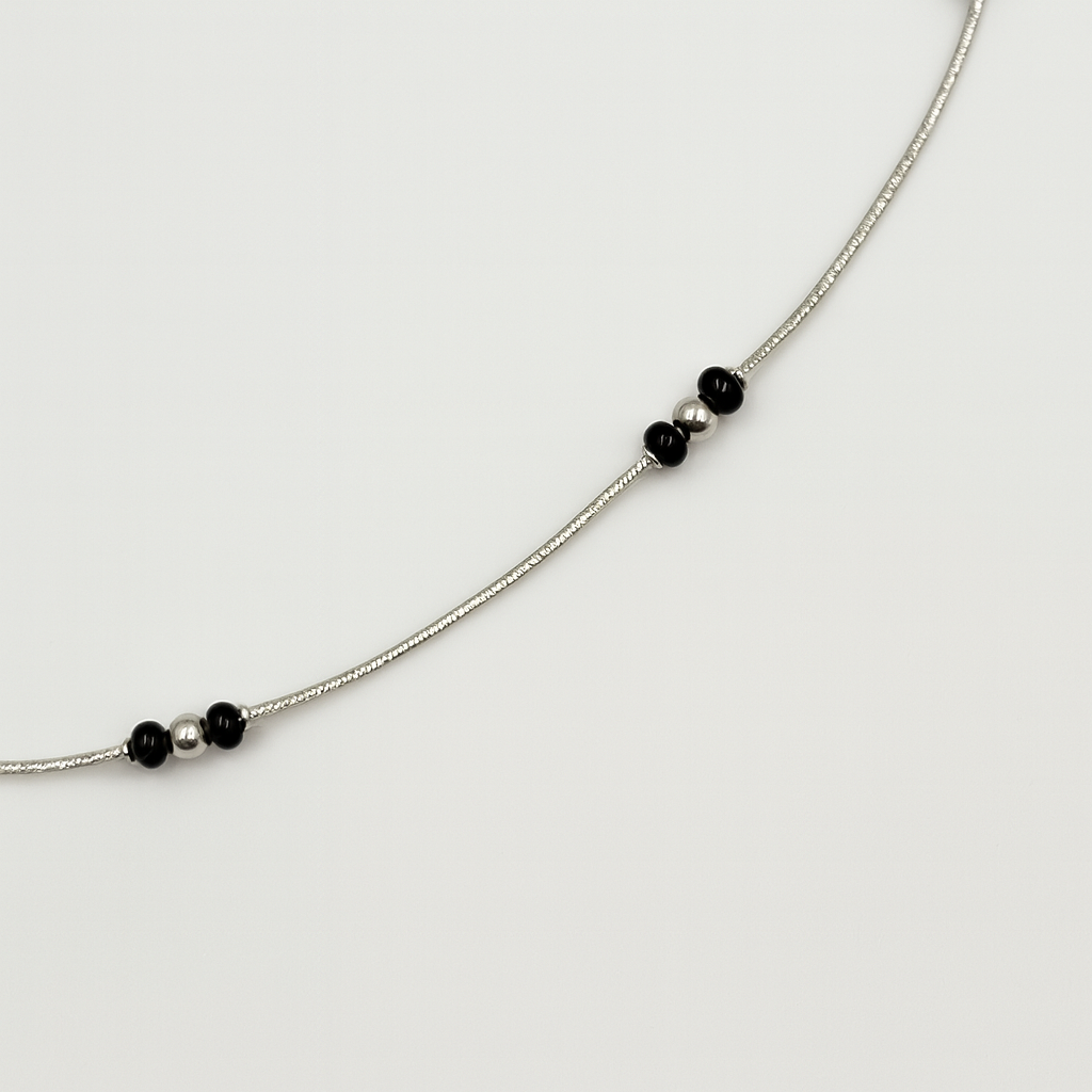 Silver anklet with black bead accents