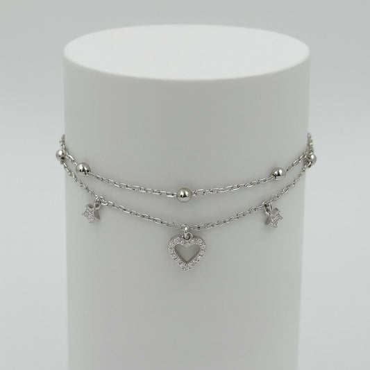 Silver layered necklace with heart charm on a white stand
