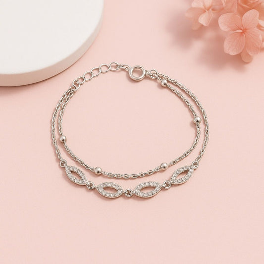 Silver bracelet with intricate design on a pink background