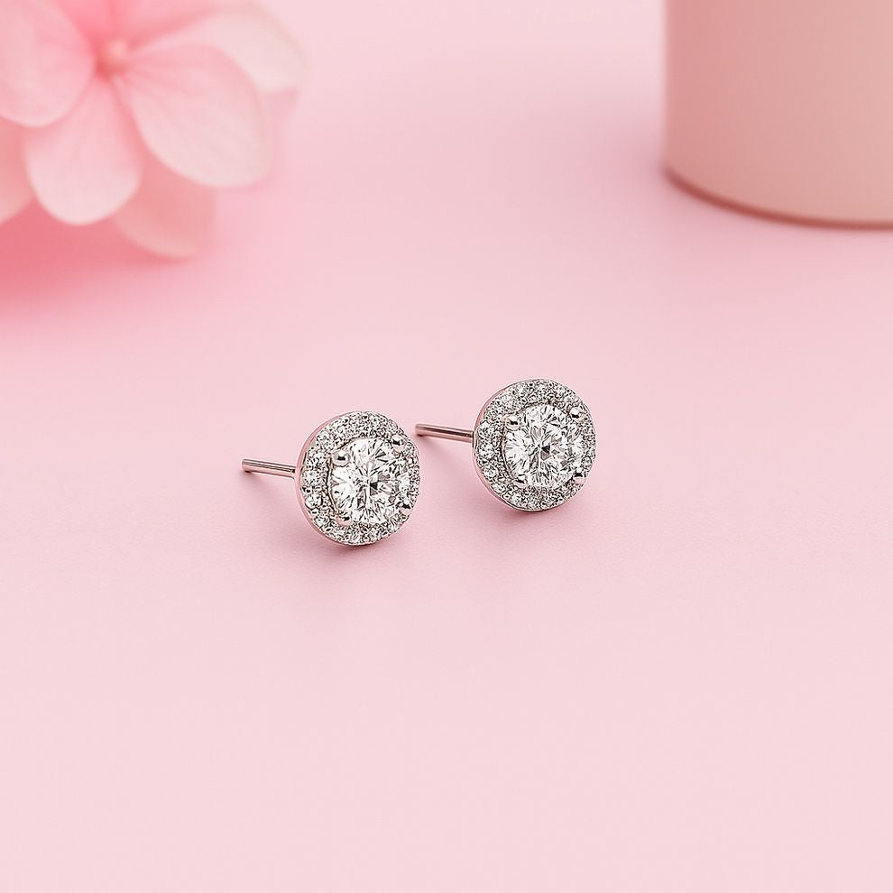 silver round earrings for women on a pink background