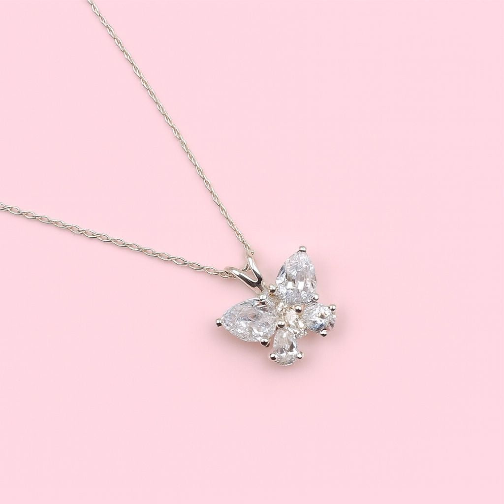 Butterfly-shaped Silver pendant on a pink background