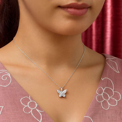Butterfly necklace on a model wearing a pink floral top with a red curtain background