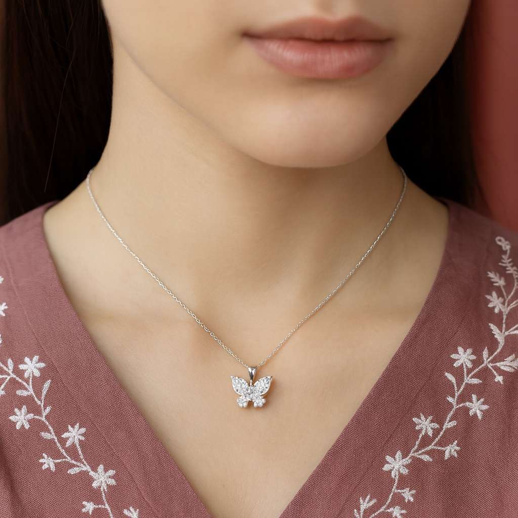 Butterfly necklace on a women wearing a pink embroidered top