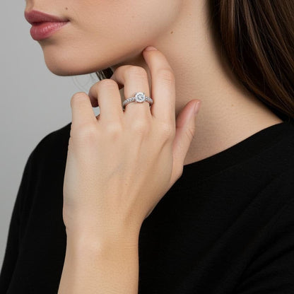 Close-up of a woman wearing silver ring on a plain background