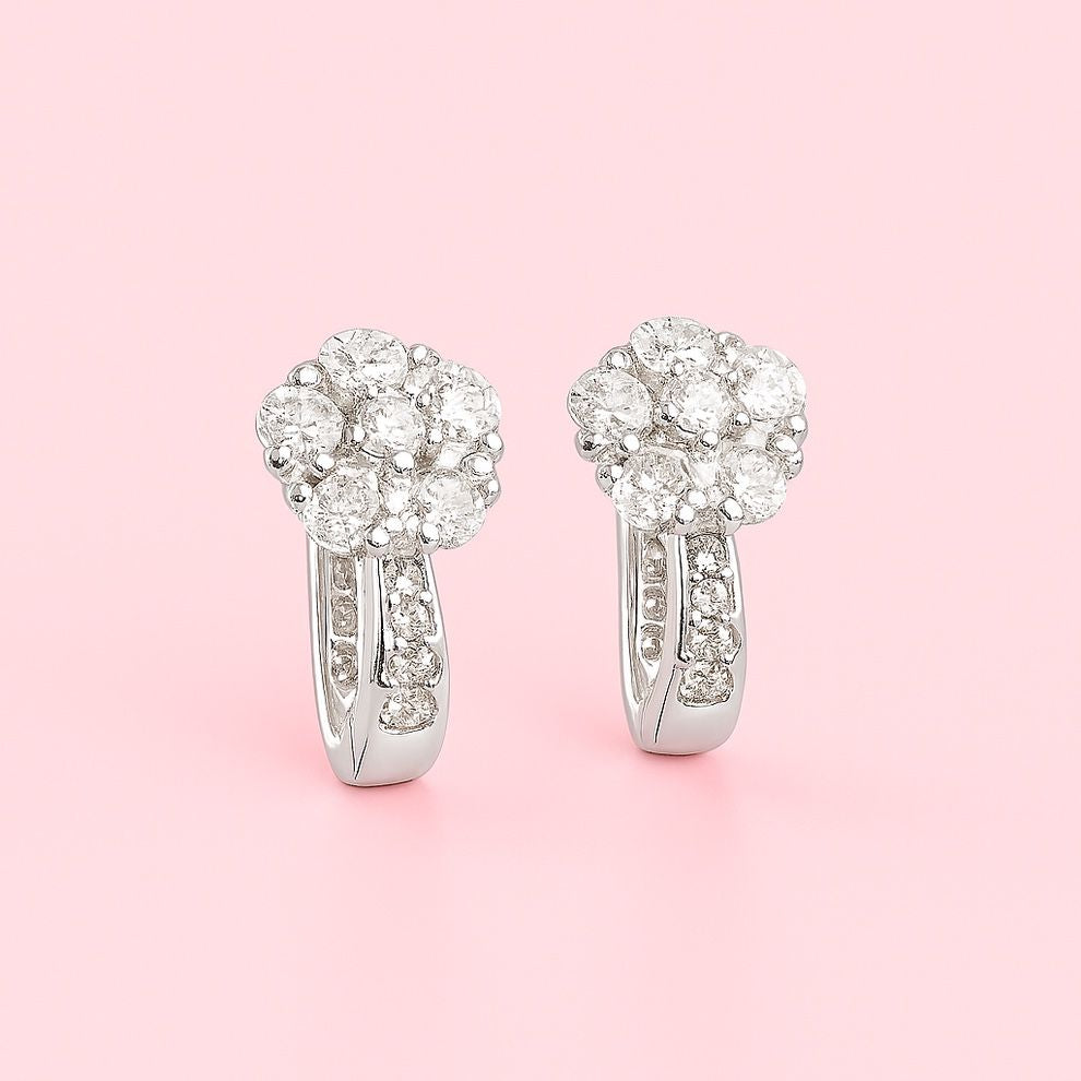 floral silver earrings on a pink background