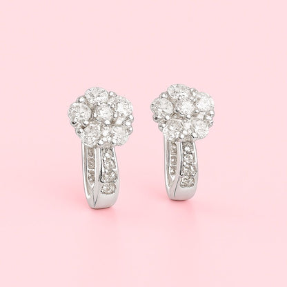 floral silver earrings on a pink background