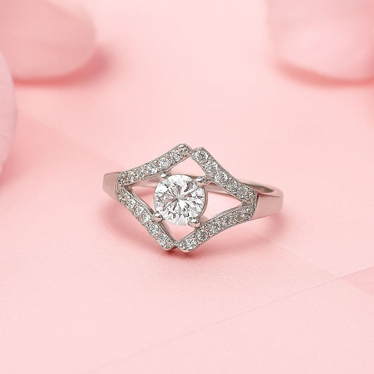 Silver ring with a diamond-shaped  stone on a pink background
