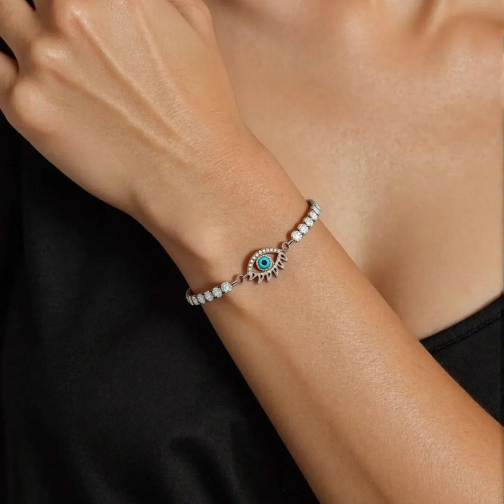 Bracelet with an evil eye design on a wrist against a black background