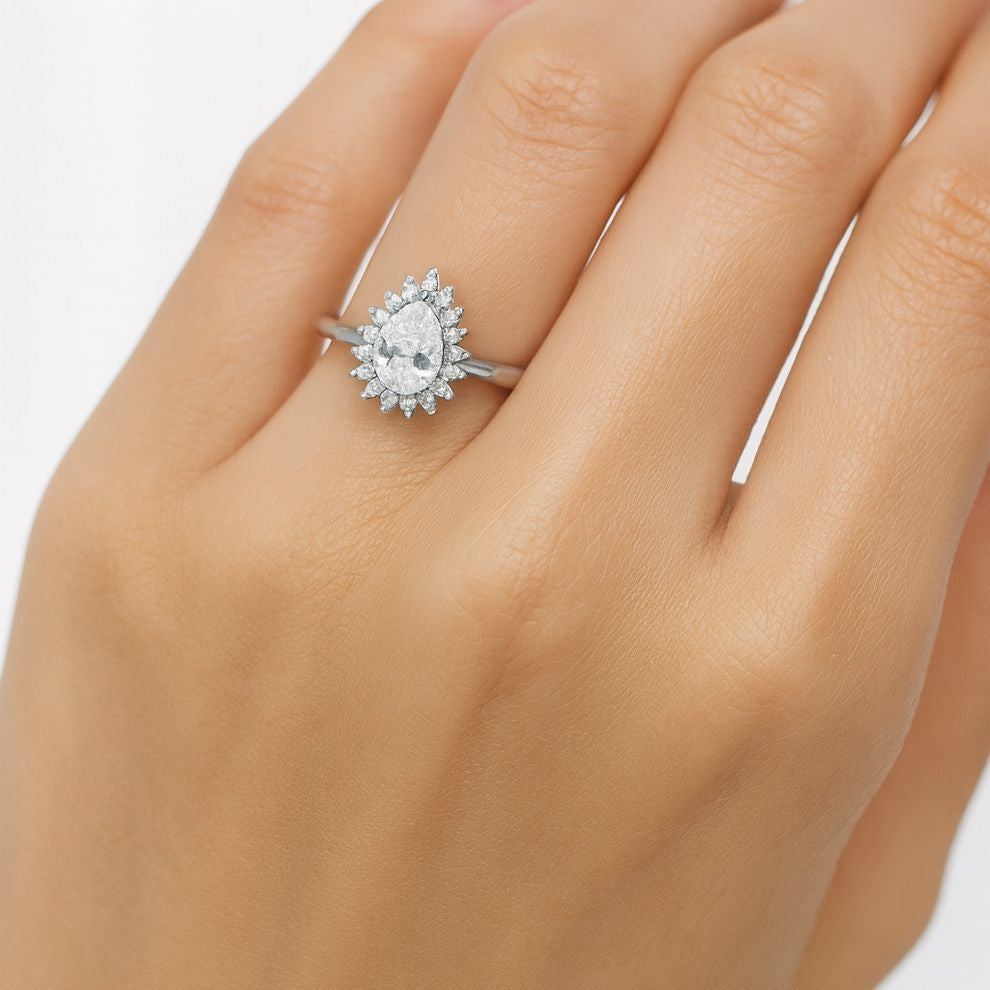 silver white stone ring on a hand with a plain background