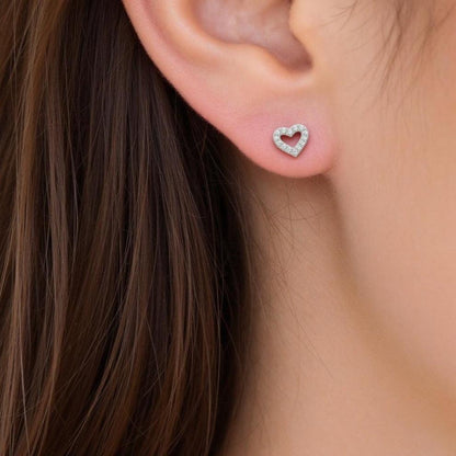 Heart-shaped studs earring worn by a women with brown hair.
