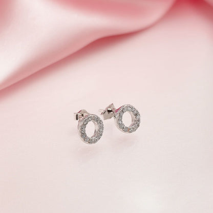 Silver earrings with oval design on a pink fabric background