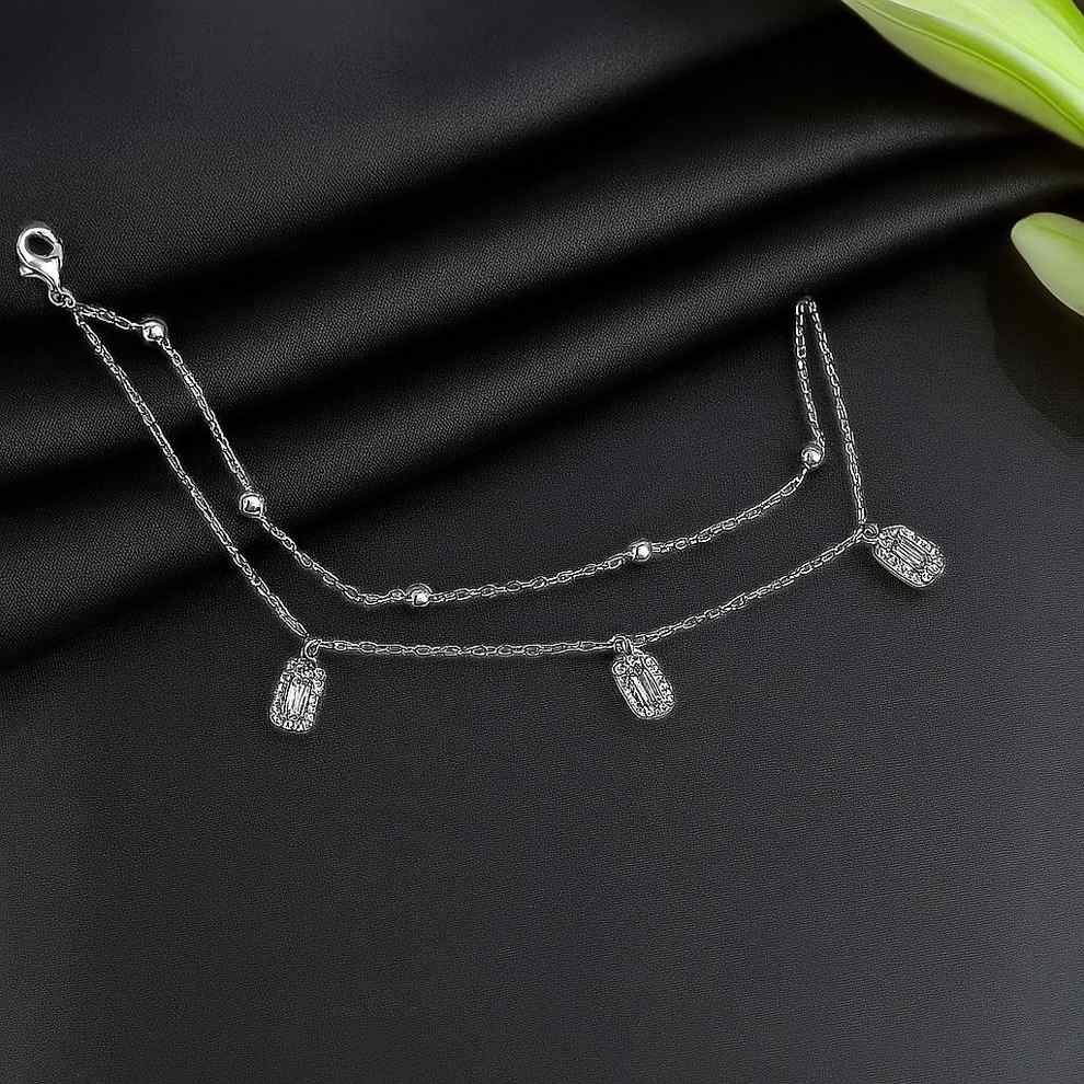 Silver bracelet with rectangular charms on a black fabric background