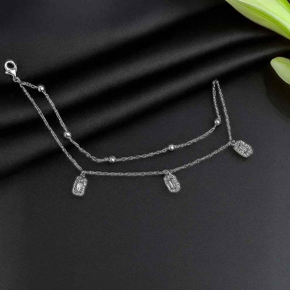 Silver bracelet with rectangular charms on a black fabric background