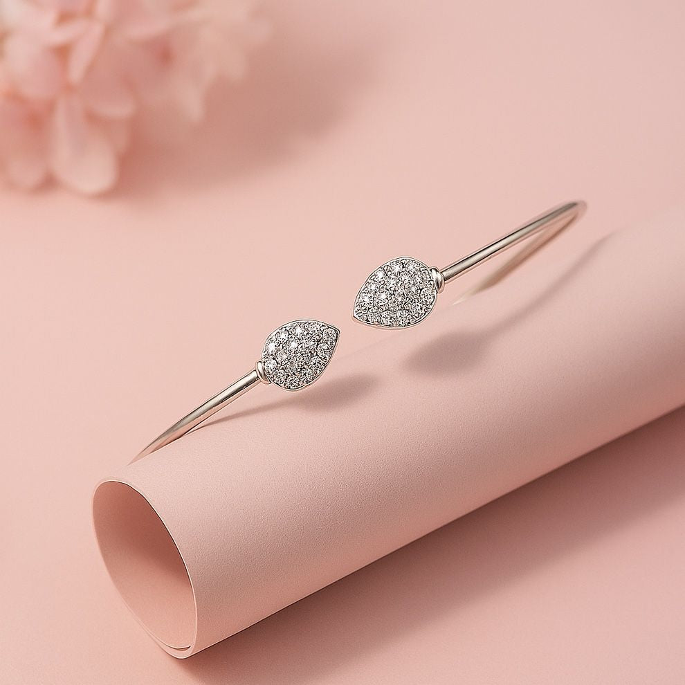 Silver bracelet with diamond accents on a pink surface