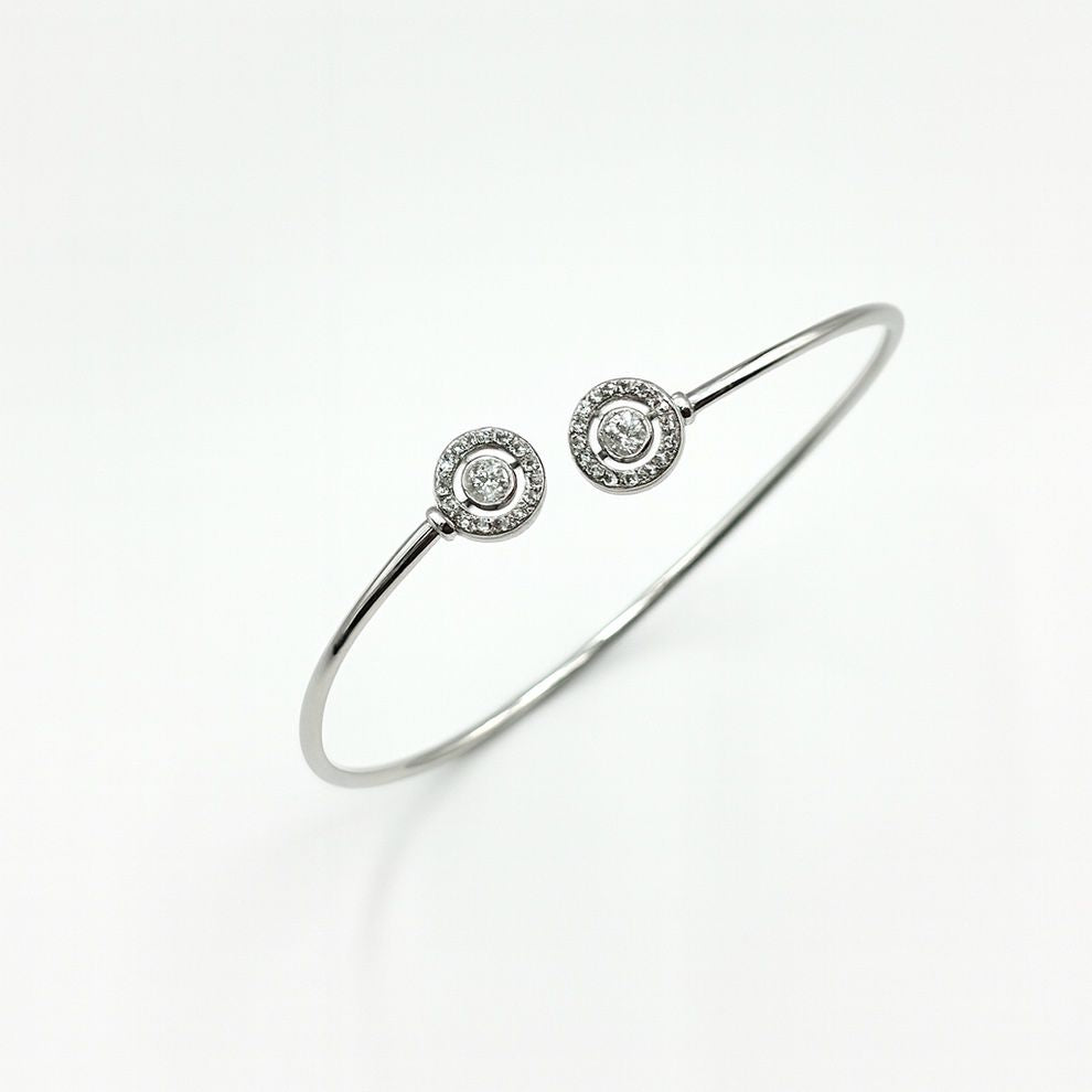 Silver bracelet with two round diamond-like stone accents on a white background