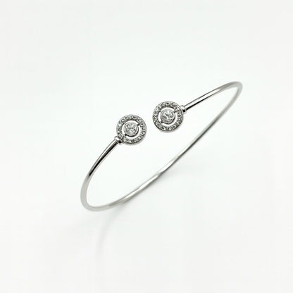 Silver bracelet with two round diamond-like stone accents on a white background