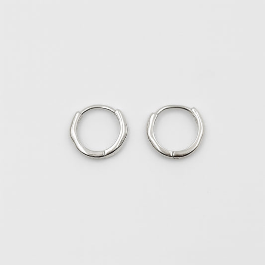 Pair of silver hoop earrings on a light gray background