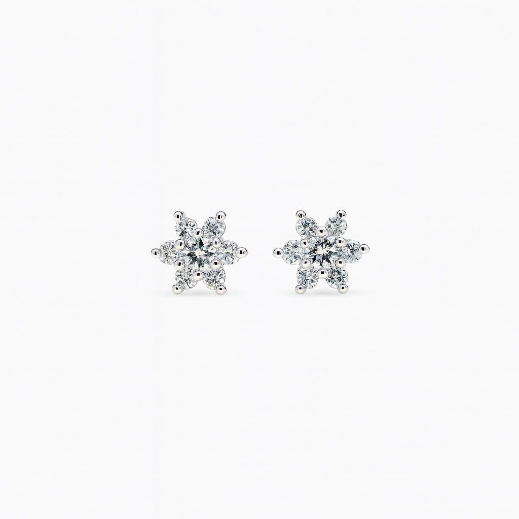 Pair of snowflake-shaped diamond earrings on a white background