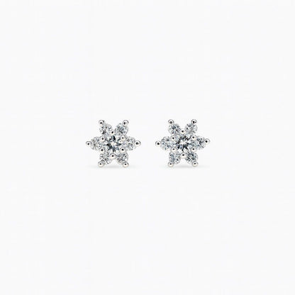 Pair of snowflake-shaped diamond earrings on a white background