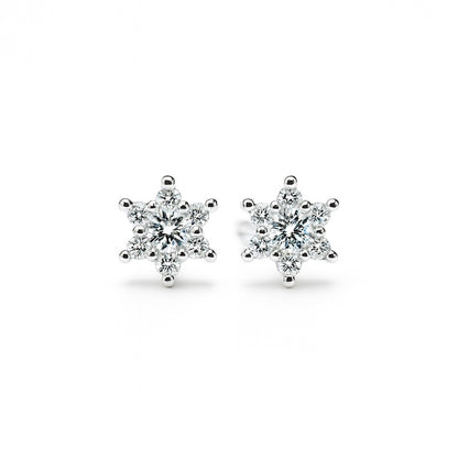 Pair of snowflake-shaped silver earrings on a white background