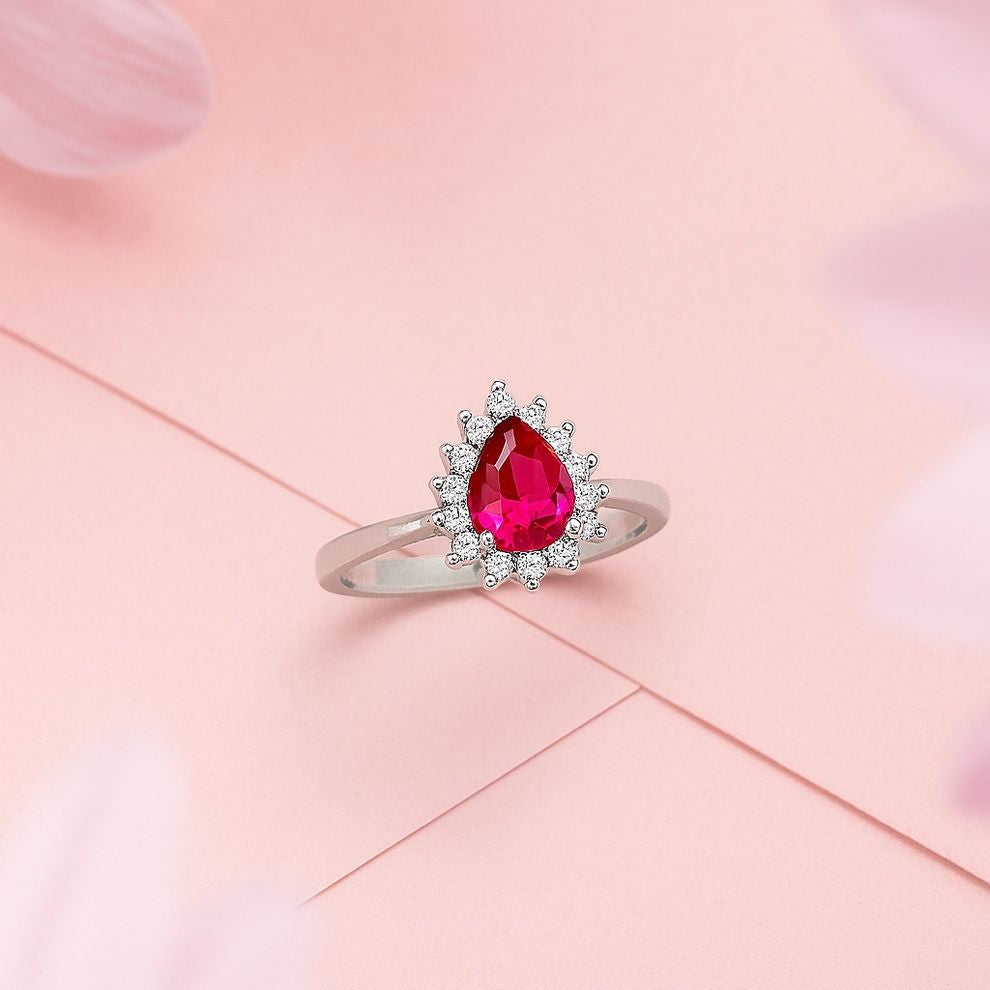 silver ring with a pink gemstone on a pink background