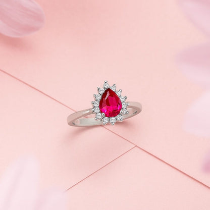 silver ring with a pink gemstone on a pink background
