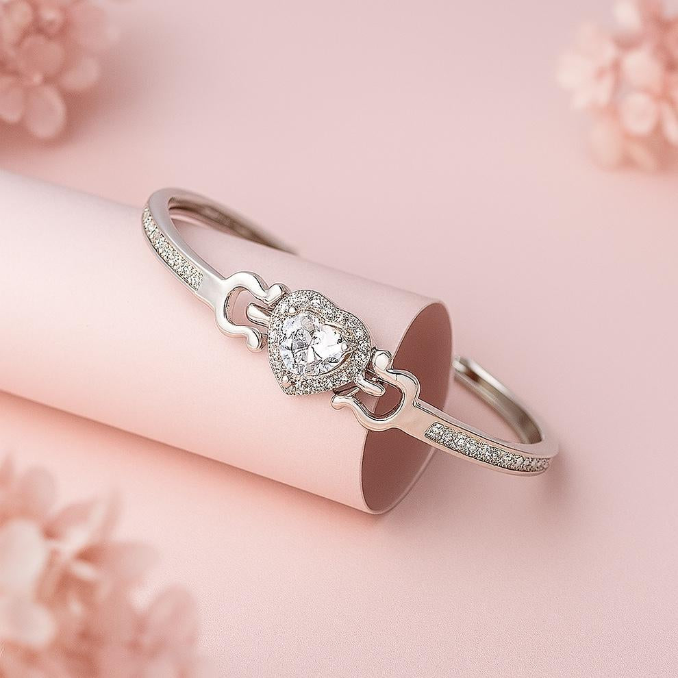 Silver bracelet with a heart-shaped clasp on a pink floral background