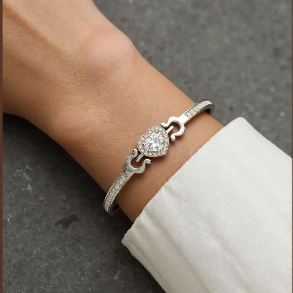 Silver bracelet with a diamond on a wrist against a gray background