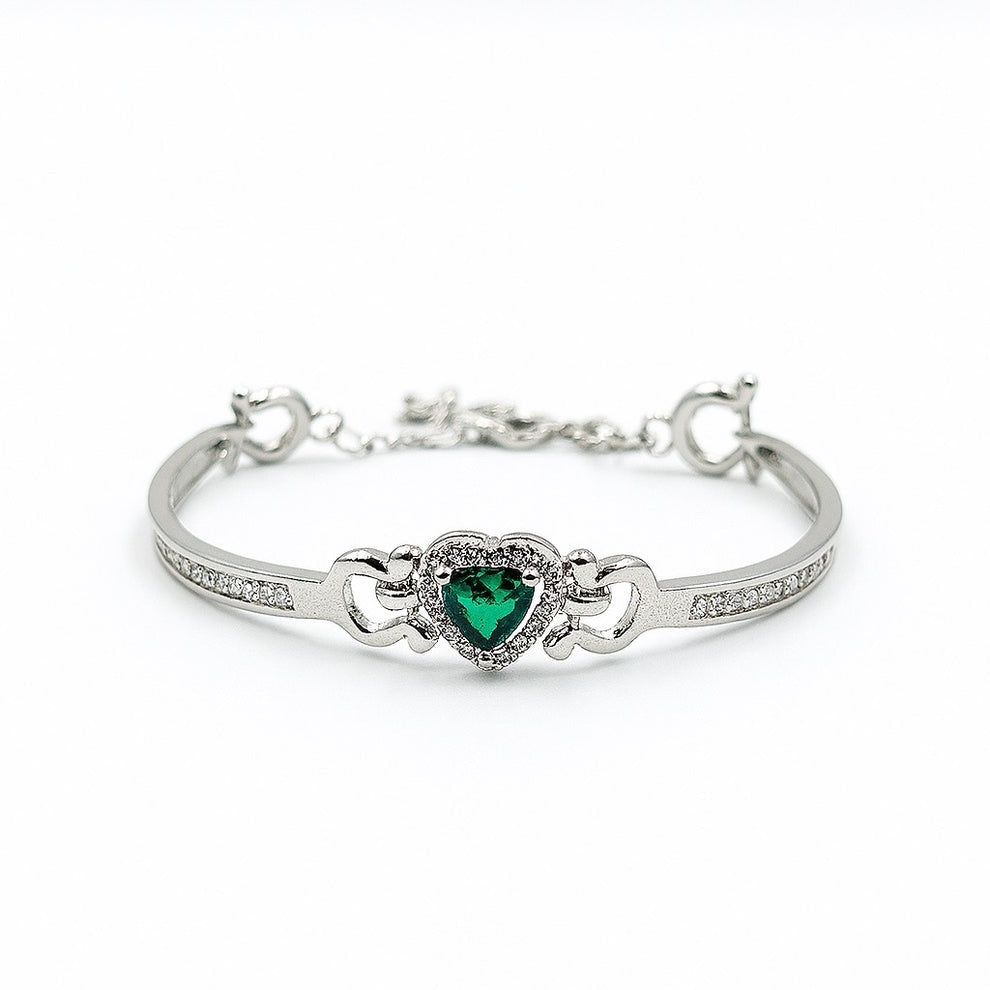 Silver bracelet with a heart-shaped green gemstone on a white background