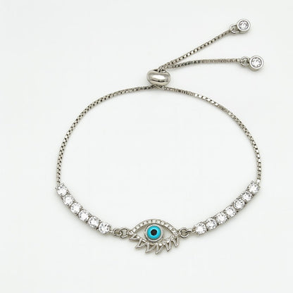 Silver bracelet with evil eye design and turquoise gemstone on a white background