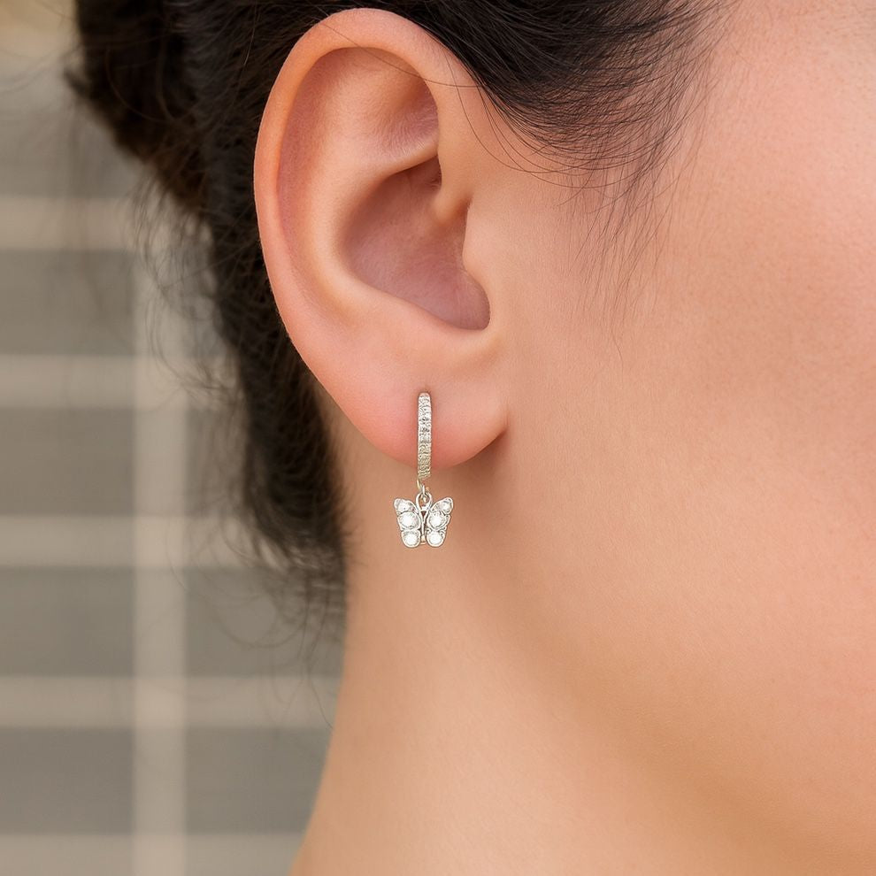 Close-up of an ear wearing a silver butterfly earring, perfect for office and college girl, everyday wear