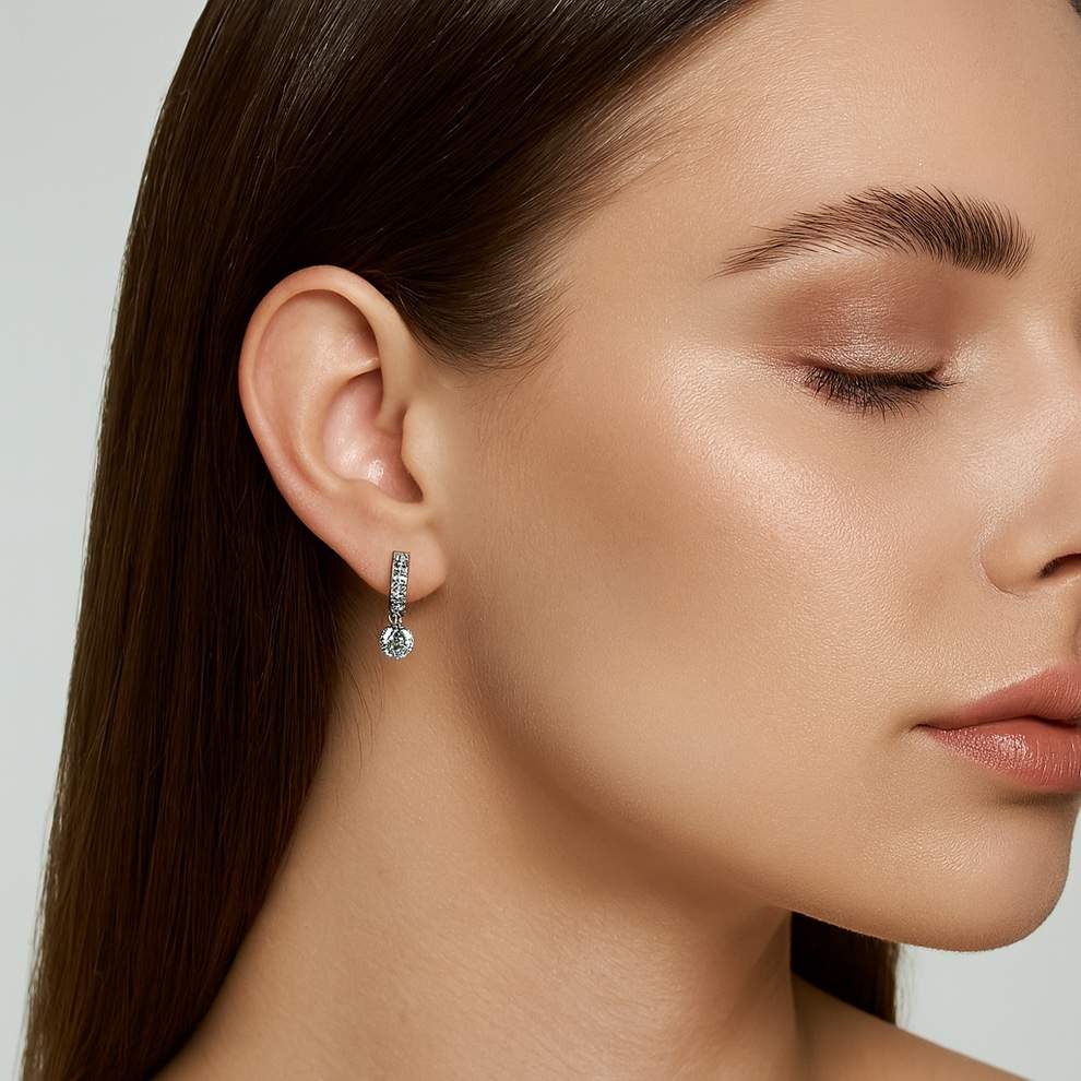Close-up of a woman wearing a silver earring with a clear gemstone, earrings perfect for outings, travel, movies and party