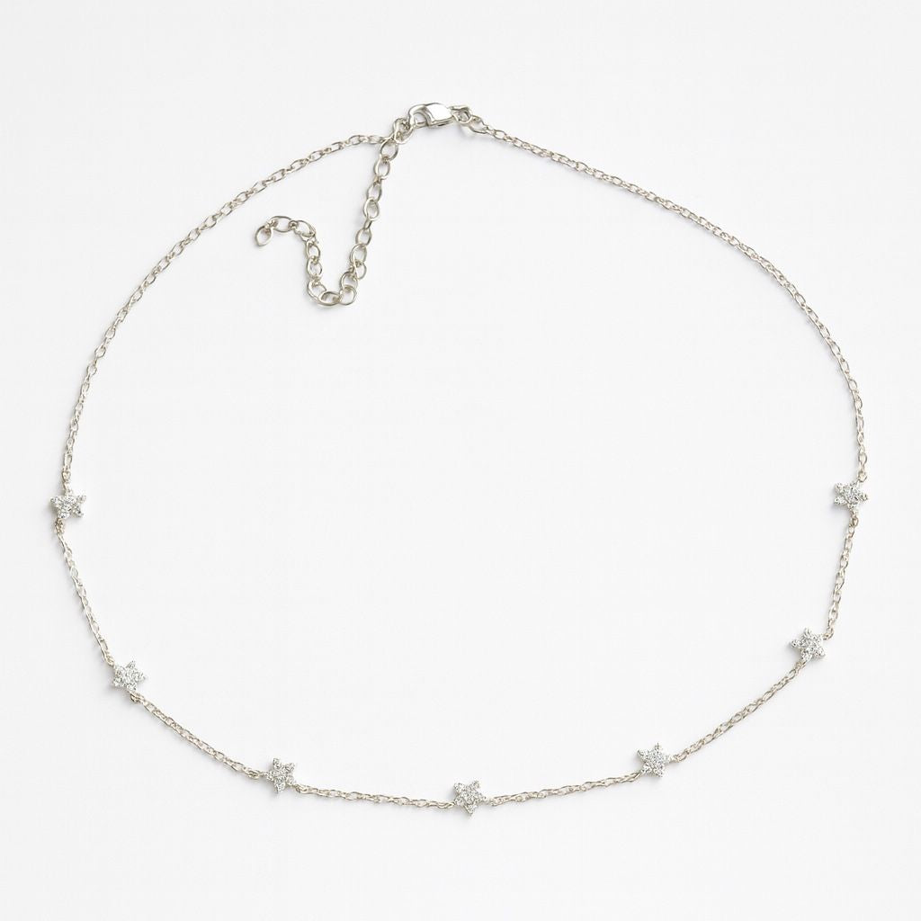 Silver necklace with star-shaped pendants on a white background