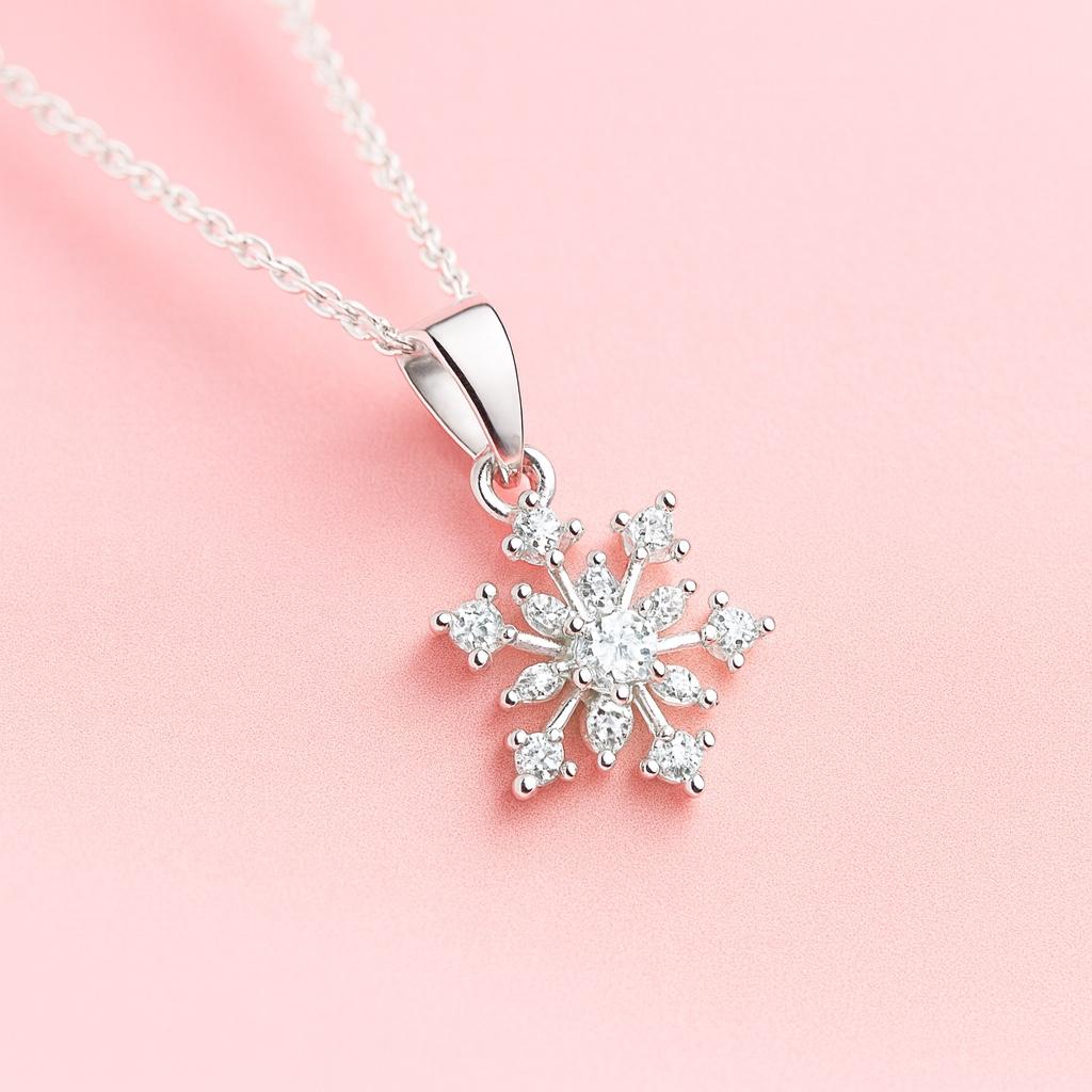 Silver snowflake pendant necklace on a pink background