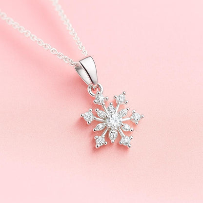 Silver snowflake pendant necklace on a pink background