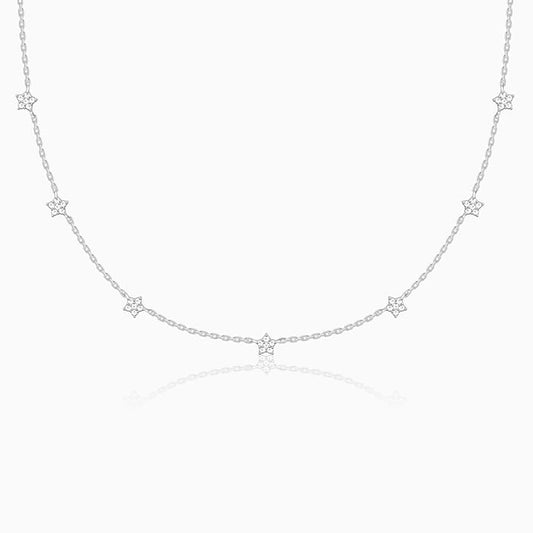Delicate silver necklace with star-shaped pendants on a white background