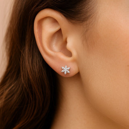 Close-up of an ear wearing a Silver stud earring with hair partially obscuring the view.