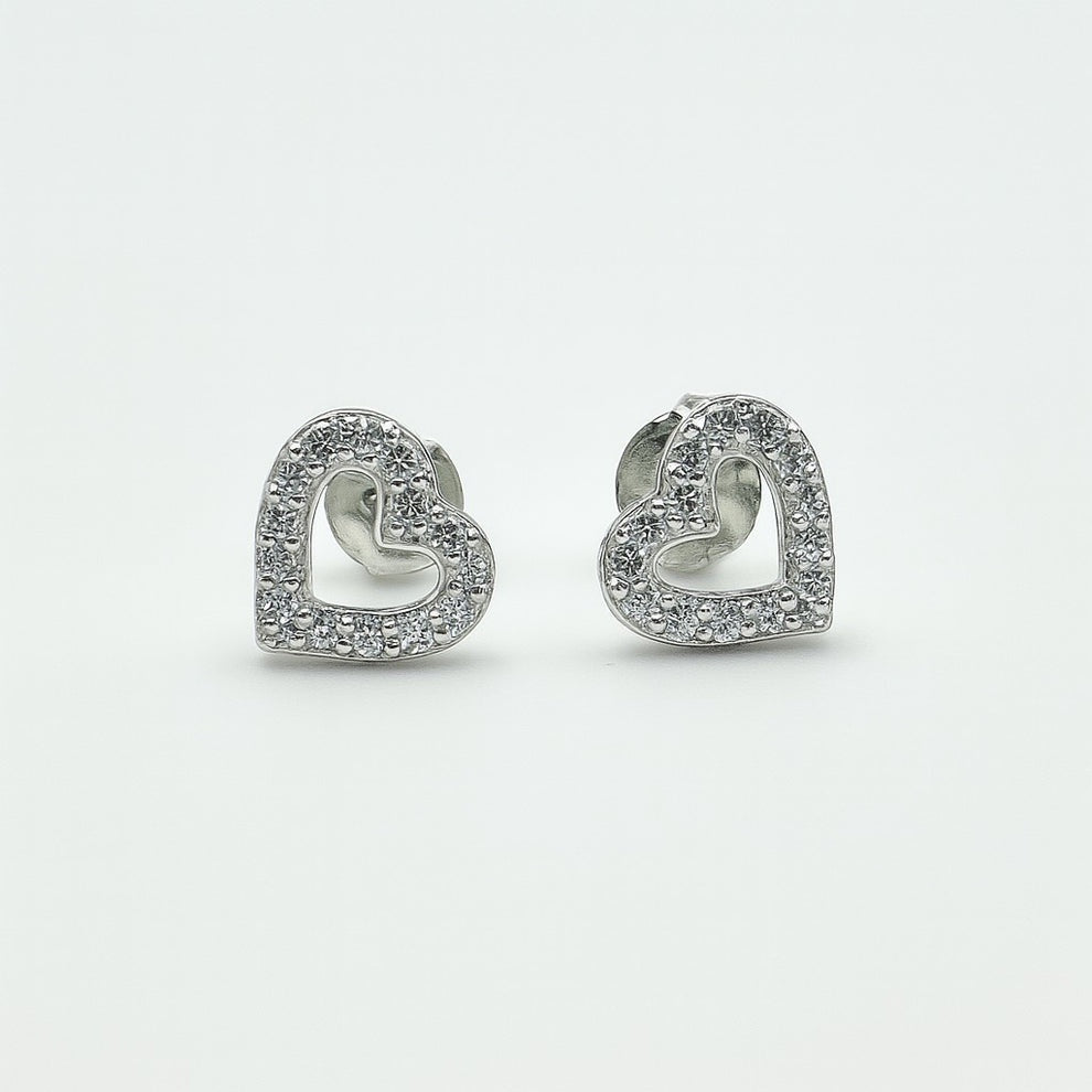 Heart-shaped silver earrings with clear stones on a white background