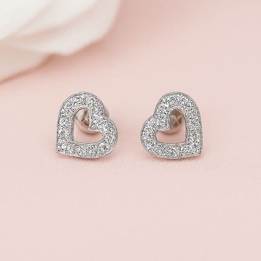 Heart-shaped earrings with clear stones on a light pink background