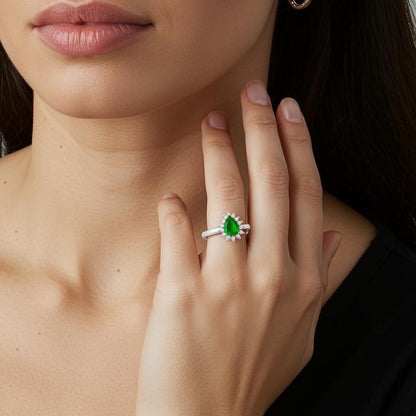Close-up of a hand wearing a green gemstone ring, engagement ring outfit