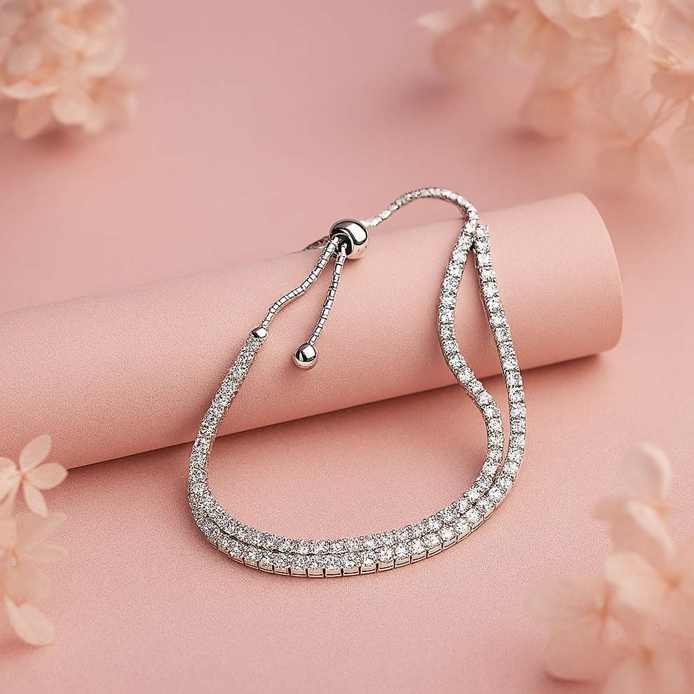 Silver bracelet with clear stones on a pink surface with floral elements