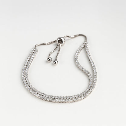 Silver bracelet with clear stones on a light gray background