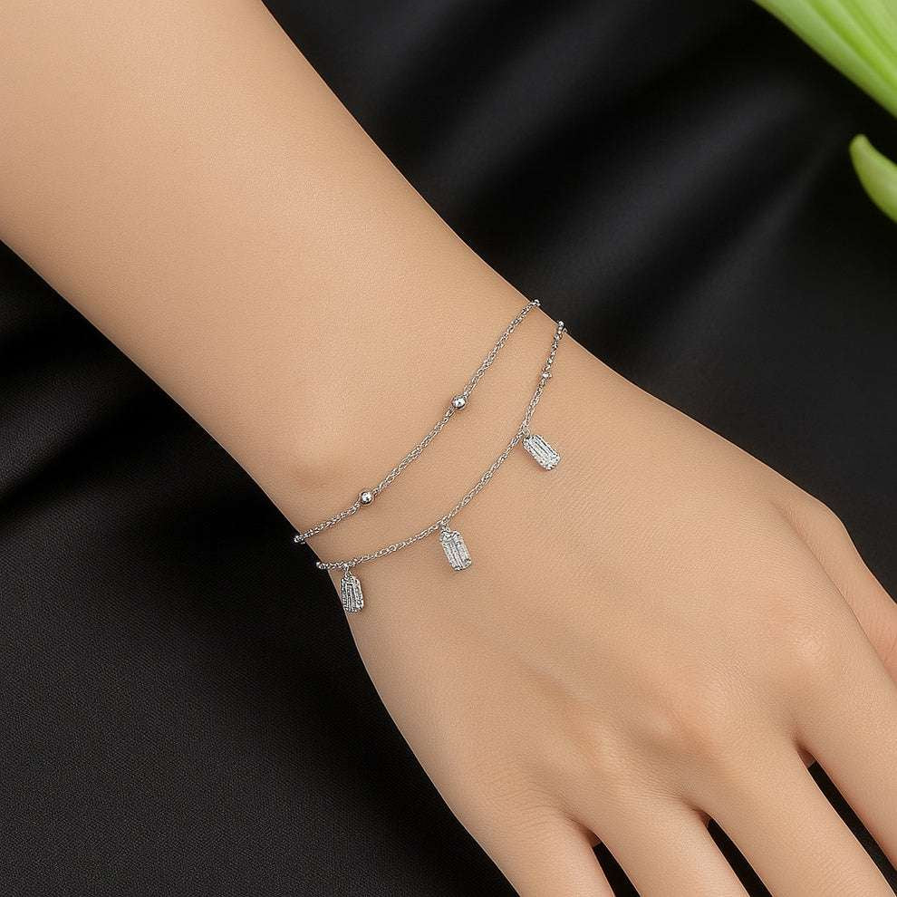 Silver bracelet on a women wrist against a black background