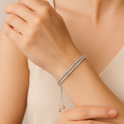 Silver bracelet on a person's wrist against a neutral background